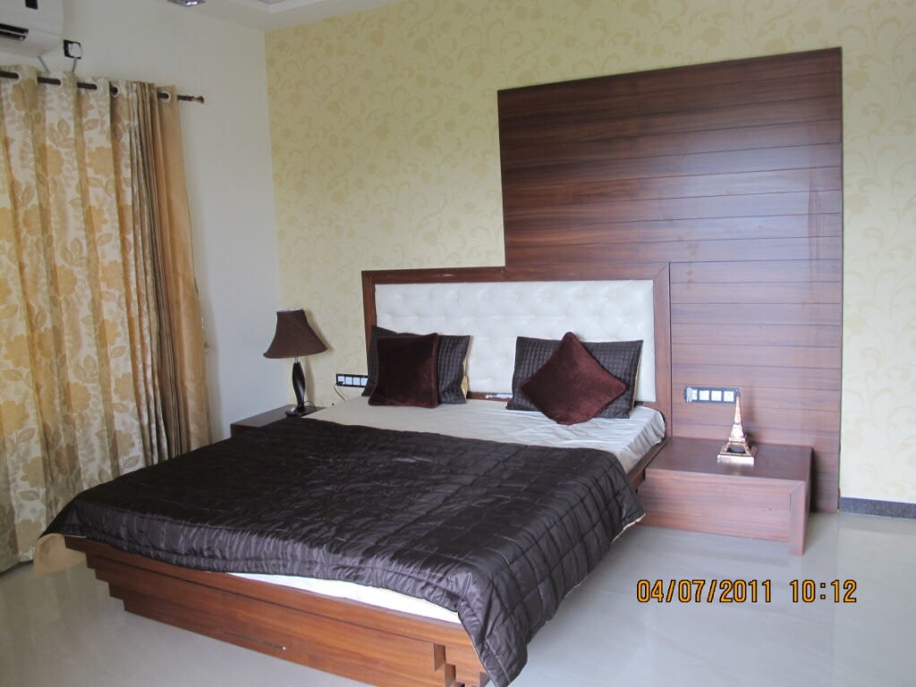 Bedroom With Timber Wood Bed And Yellow Curtains by Kalyani Kulkarni Bedroom Contemporary | Interior Design Photos & Ideas