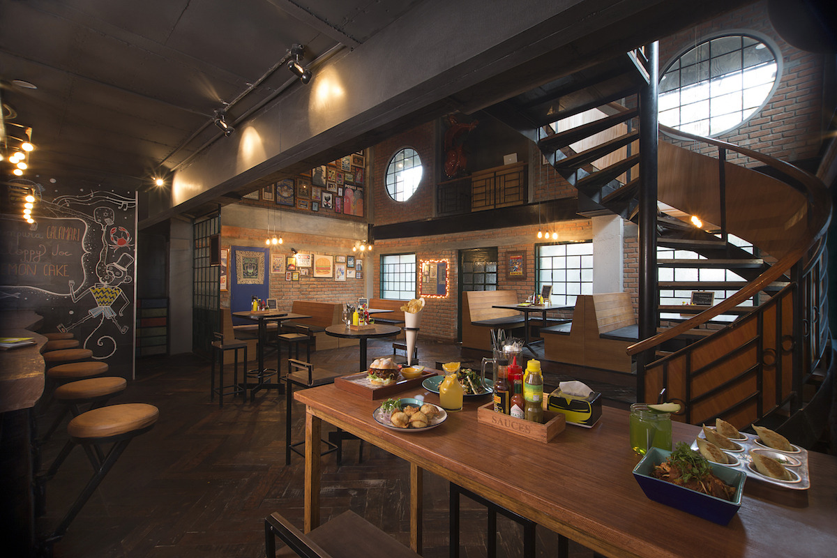 Restaurant With Twisted Staircase And Wooden Furniture by Jatin Hukkeri