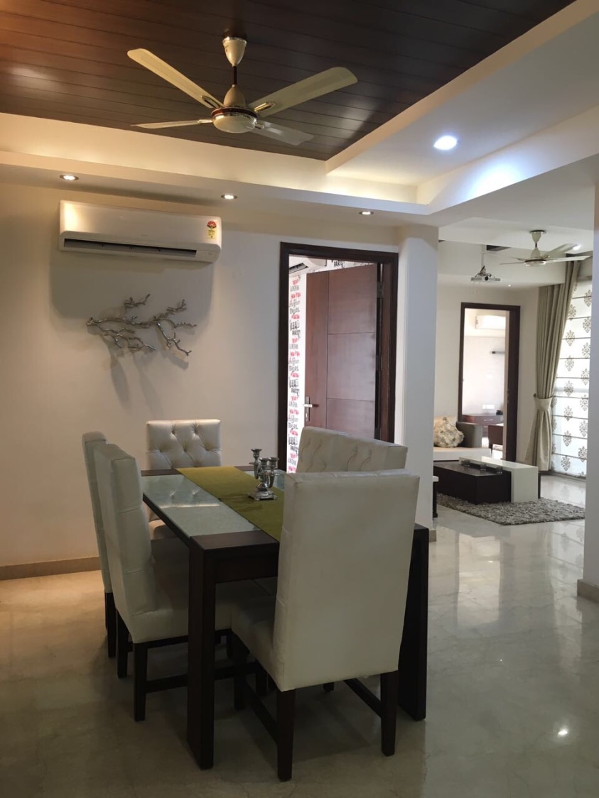 Regal Dining Room With White Leather Side Chairs and Glass Top Dining Table by Neha Chopra Dining-room Modern | Interior Design Photos & Ideas