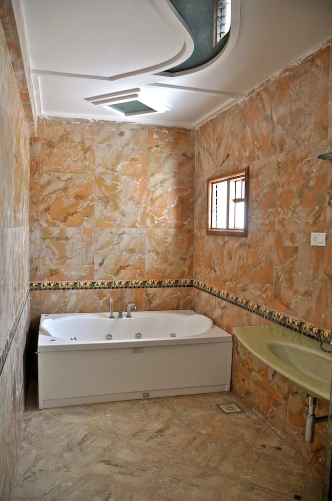 Bathroom with Patterned Tiles Walls and White Bathtub by Viraf Laskari Bathroom Modern | Interior Design Photos & Ideas