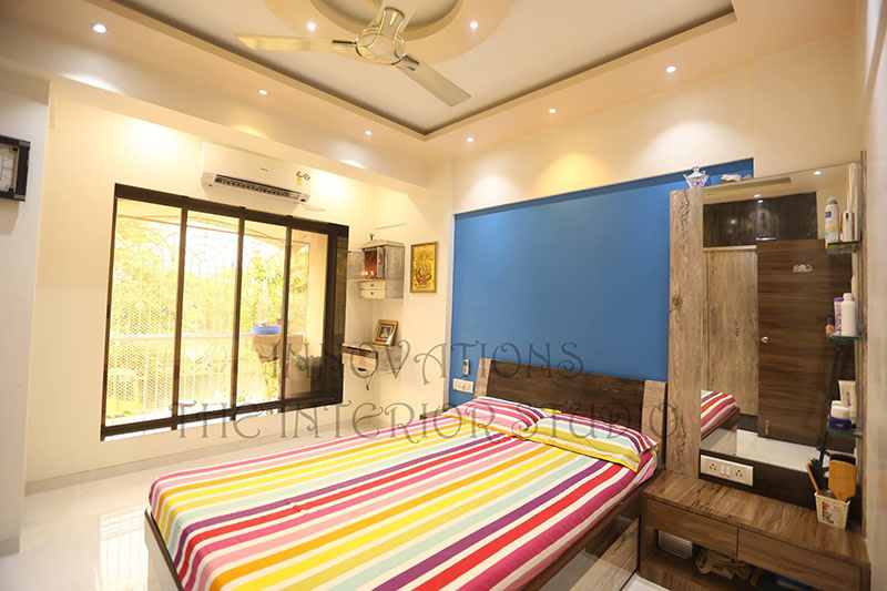 Bedroom With Cobalt Blue Wall and Wooden Low-Floor Bed by Innovations - The Interior Studio
