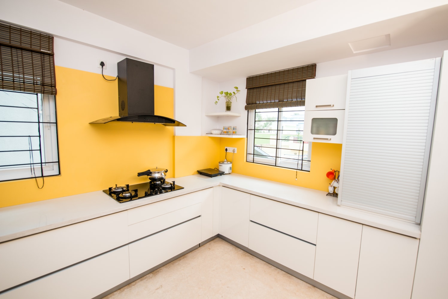 White Themed Modular Kitchen with L Shaped Counter and Yellow Walls by Shyama Viswanathan