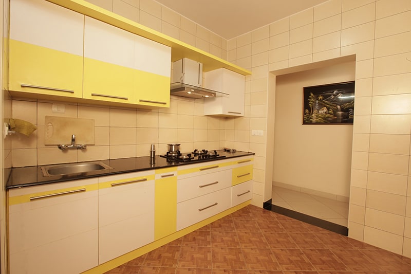 Modular kitchen with yellow cabinets by Amrath Acharya