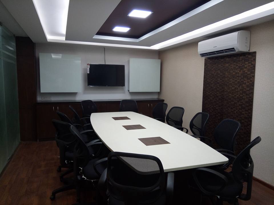 Meeting space with white table and black chairs around by Ganesh Contemporary | Interior Design Photos & Ideas