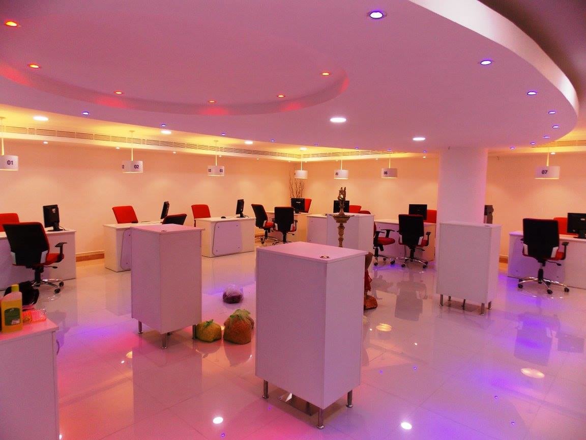 open office space with false ceiling and white table and red chair by Ganesh Contemporary | Interior Design Photos & Ideas
