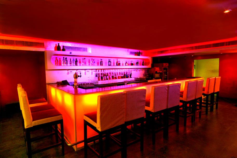 Classy Looking Bar with Red Lighting and White Chairs by Mayank Manchanda Modern | Interior Design Photos & Ideas