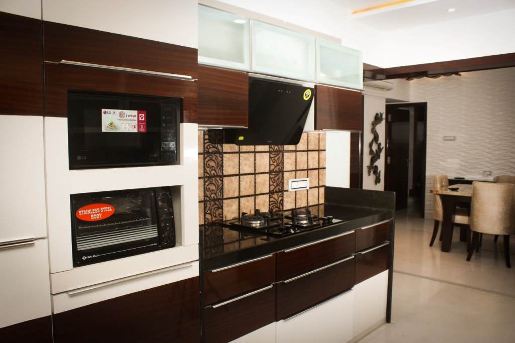 Wooden Cabinets In Modular Kitchen with black marble top by VERSATILE INTERIORS Modular-kitchen Modern | Interior Design Photos & Ideas