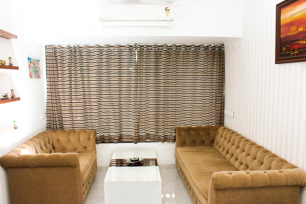 Beige Sofa Set And Stripped Curtains In Living Area by VERSATILE INTERIORS Living-room Contemporary | Interior Design Photos & Ideas