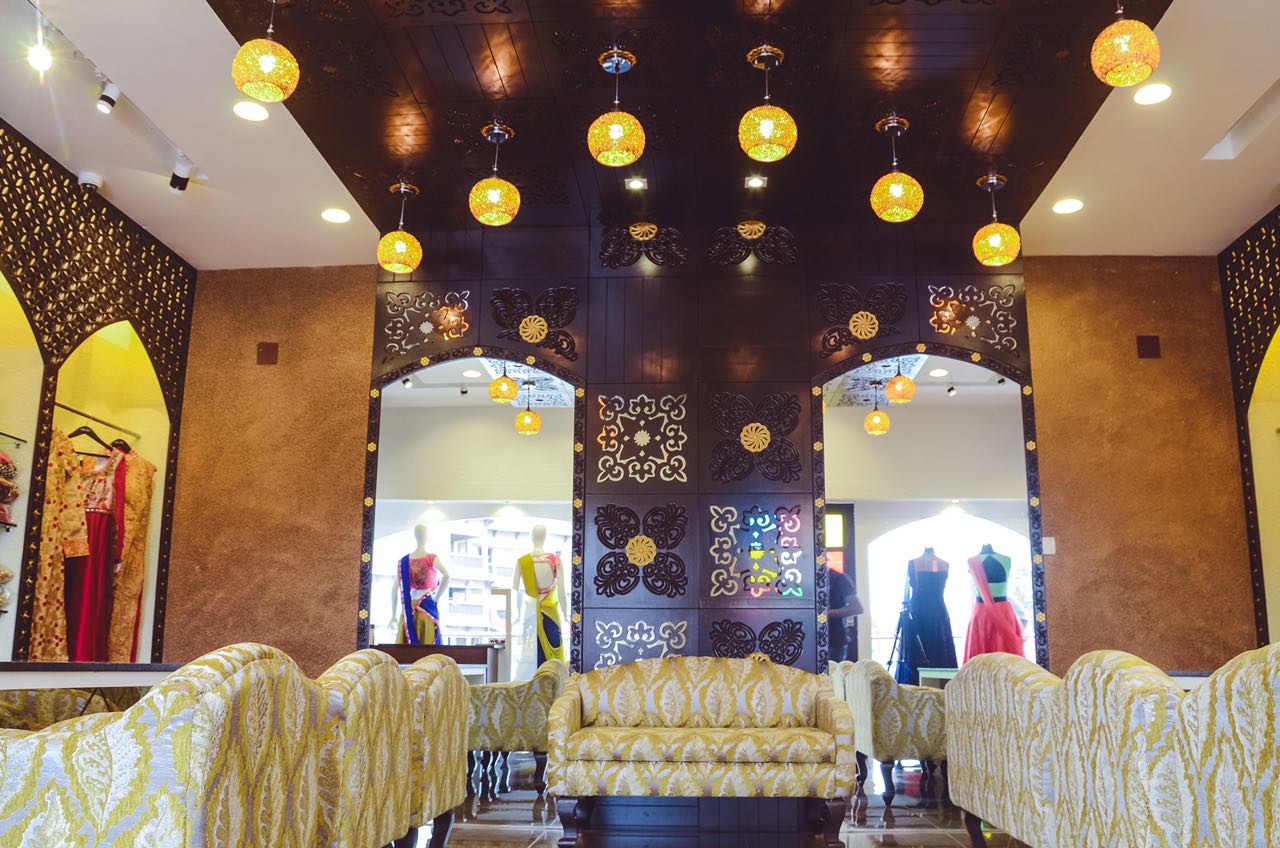 Showroom With Golden Wooden Sofas And Pendant String Lights by Nirav Gor | Interior Design Photos & Ideas