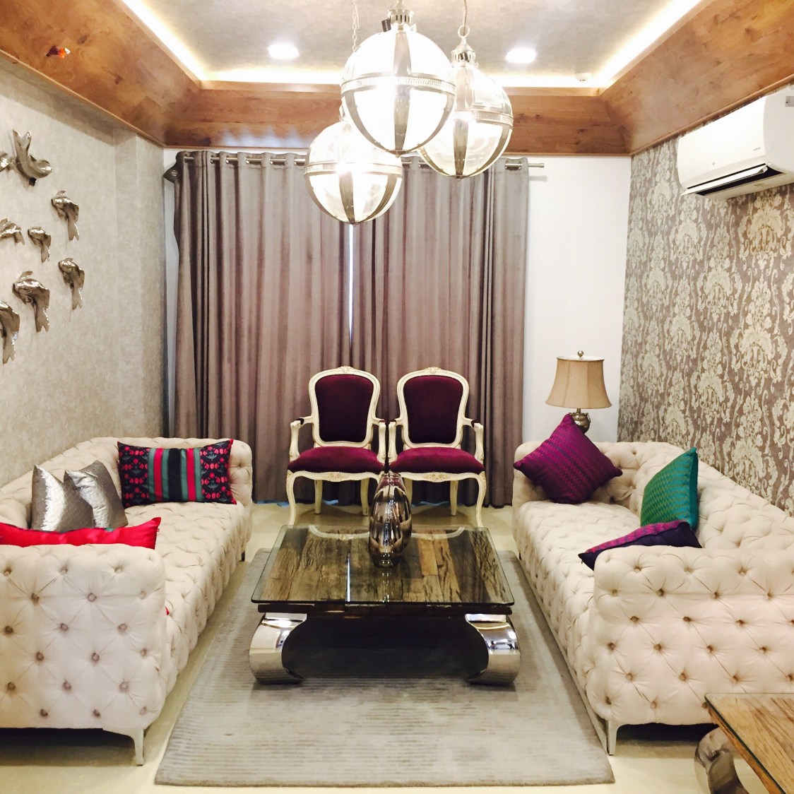 Life of the house:beige themed living room with tuxedo sofa and hanging decorative lights by Chaitanya Challa Living-room Eclectic | Interior Design Photos & Ideas