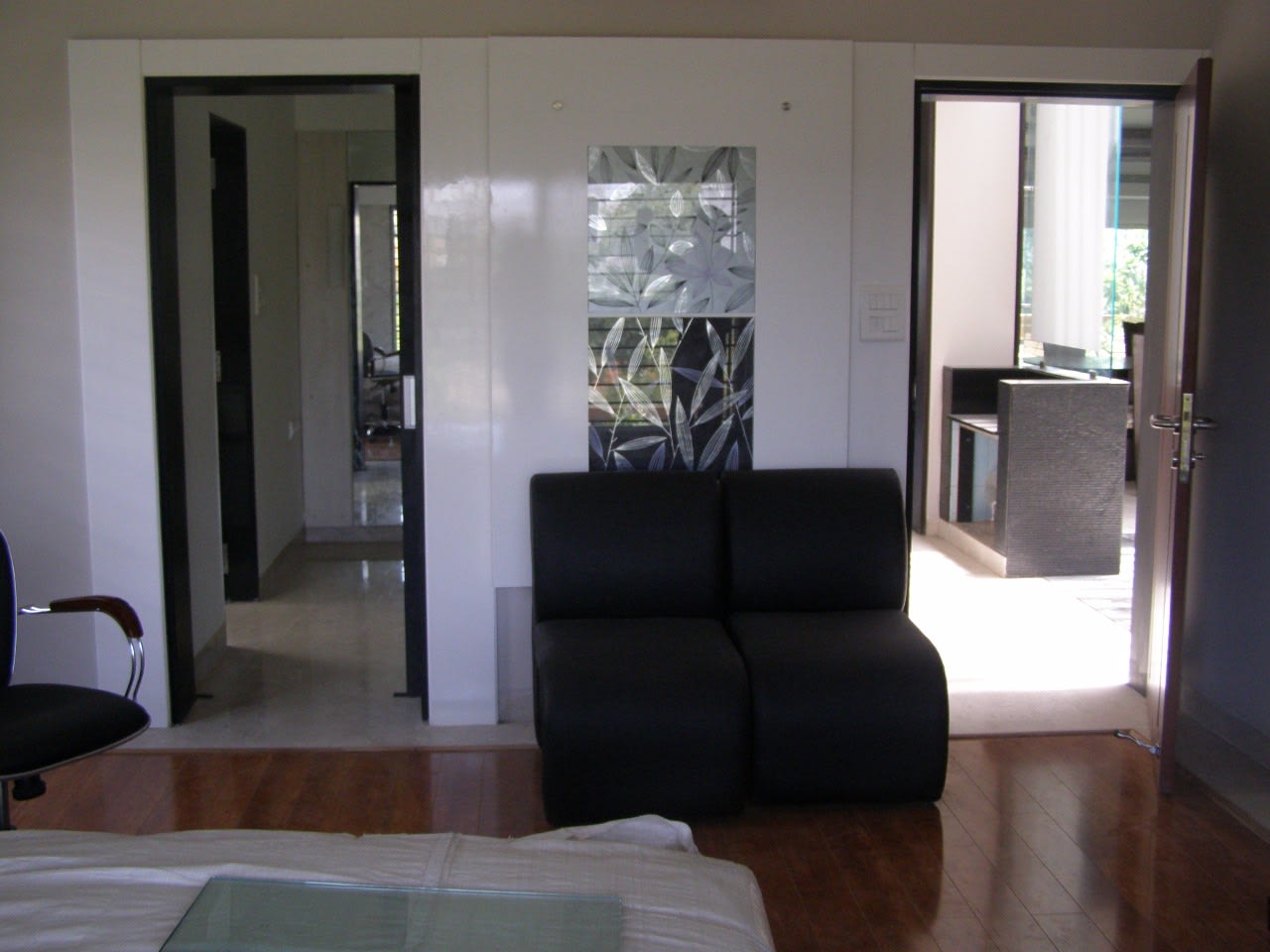 Wooden flooring and black sofa in living room by Richa Jindal Contemporary | Interior Design Photos & Ideas