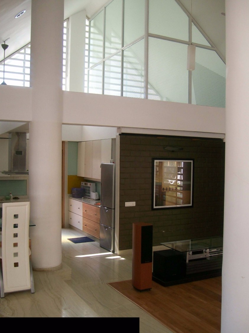 Hallway with wooden flooring and brick wall design by Richa Jindal