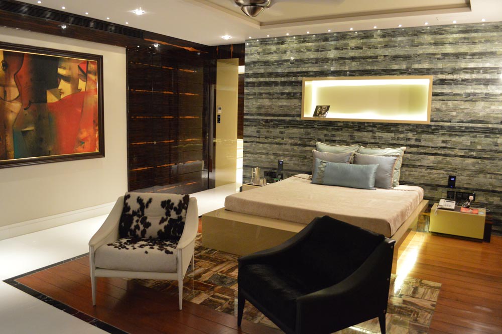 Mordern stule bedroom with hardwood wooden flooring,high rise queen sized bed and tub chairs by Gocosy.com Modern | Interior Design Photos & Ideas