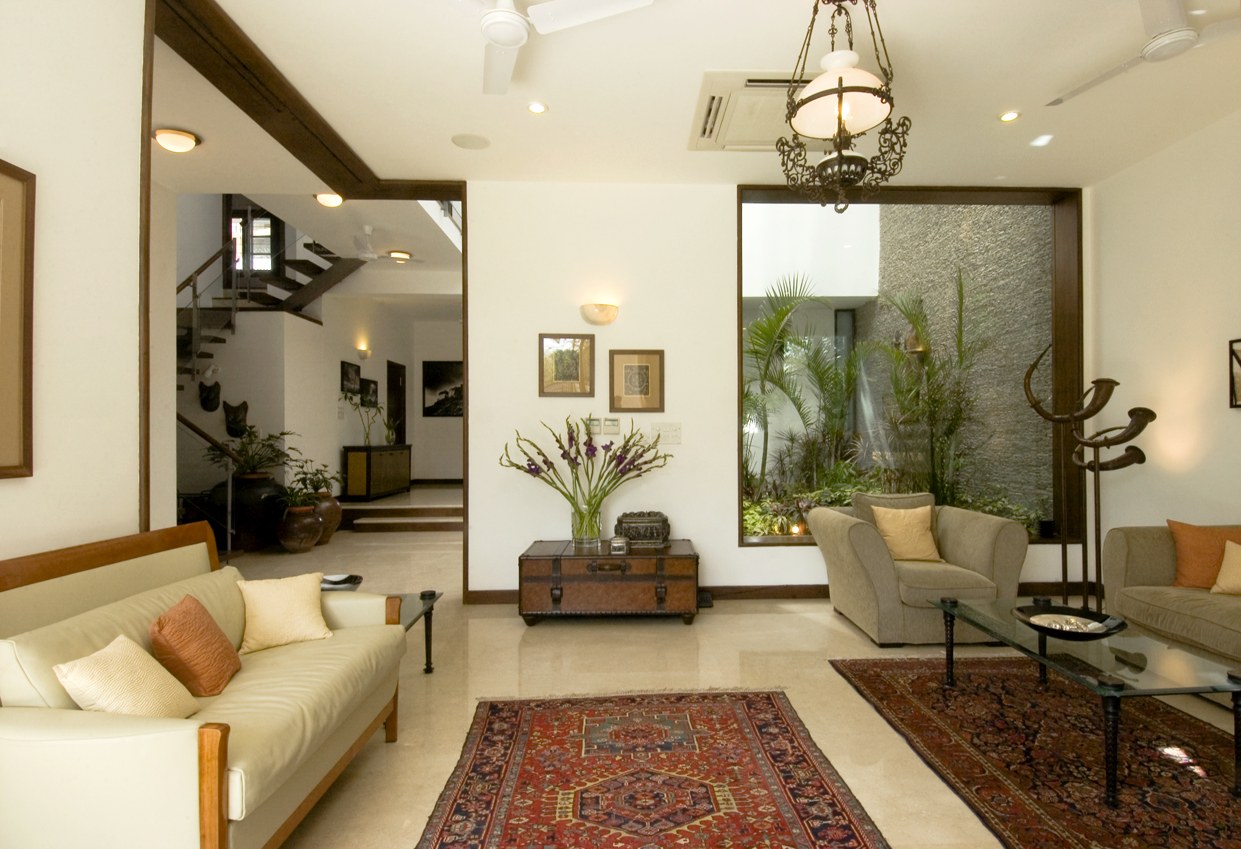 Living Room With Wooden Sofa Lemon Sofa And Traditional Red Carpet by narayan moorthy