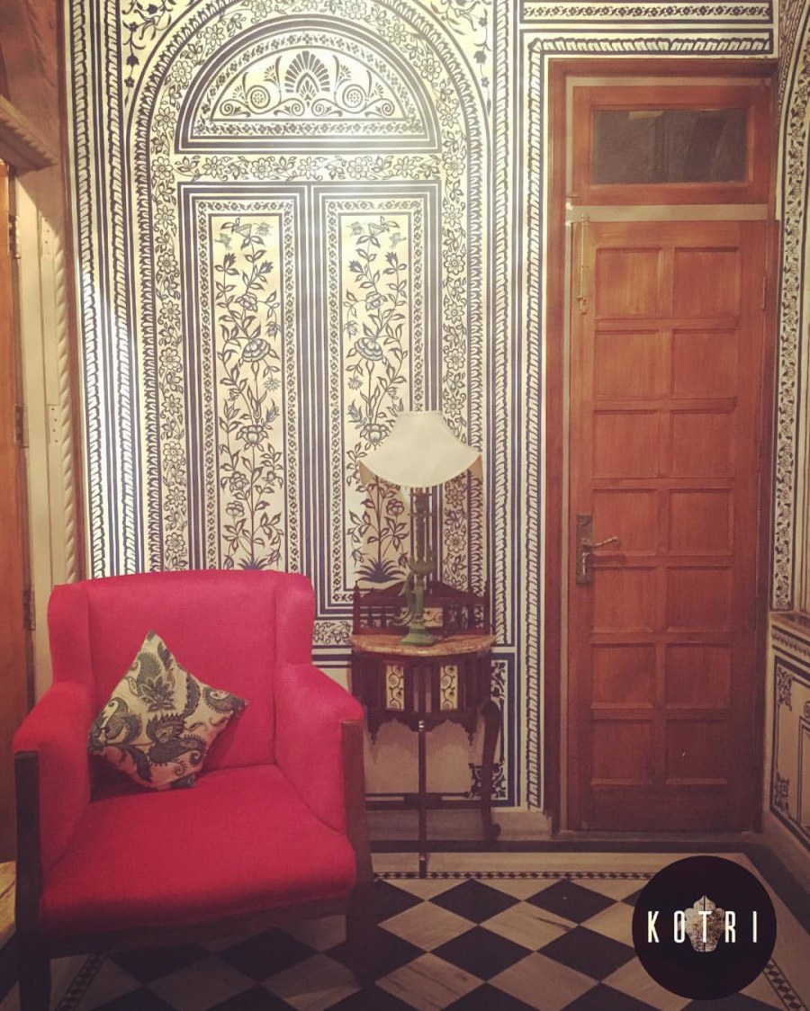 Authentic Indian floral wall art with Festive red tub chairs and black and white tiled floor by The Kotri Living-room Traditional | Interior Design Photos & Ideas