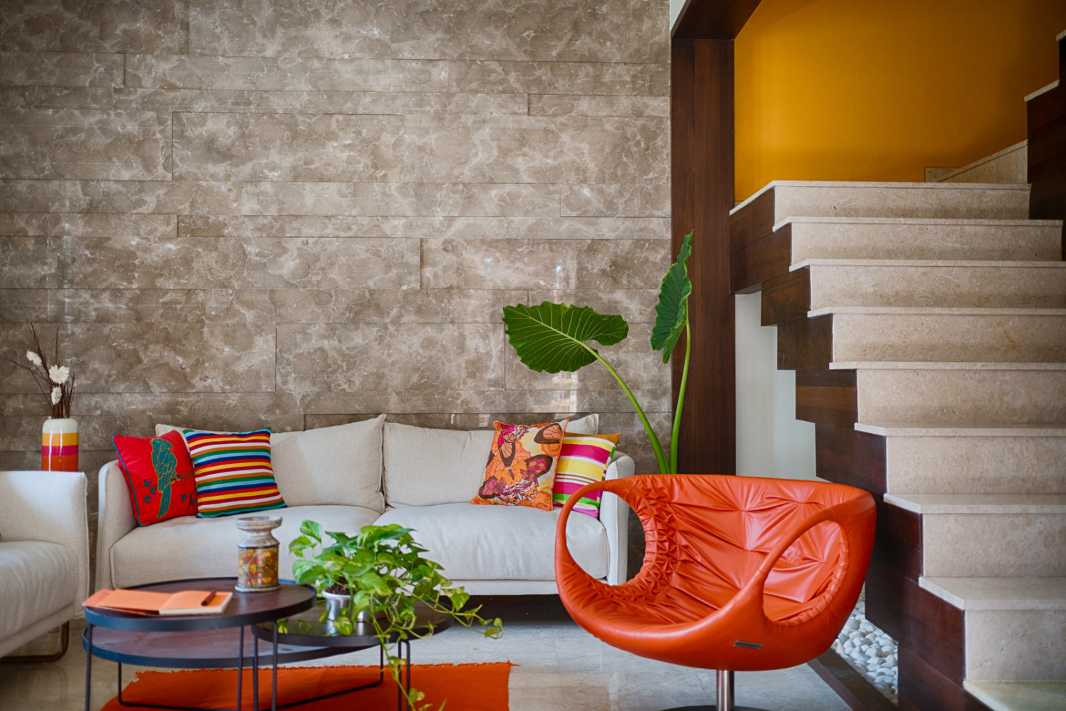 Beige patterned Wall with Orange Lounge Chair and Colorful Cushions Complimenting with White Sofa by Dhaval Patel Living-room Contemporary | Interior Design Photos & Ideas
