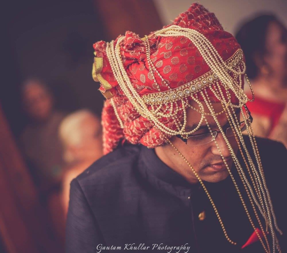 Candid Shot Of The Groom In A Red Safa With Golden Detailing And Pearls by Gautam Khullar Wedding-photography Groom-wear-and-accessories | Weddings Photos & Ideas
