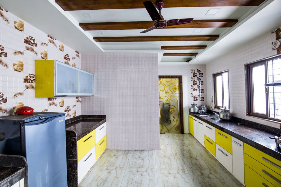 Spacious Modular Kitchen with Yellow and White Cabinets and Black Counter Top by Trupti Ladda Modular-kitchen Modern | Interior Design Photos & Ideas