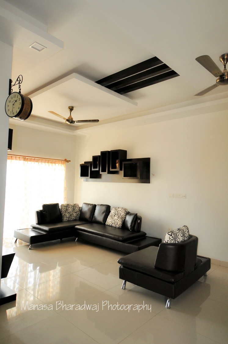 Spacious Living Room with L Shaped Black Sofa and Wooden Shelves by Manasa Bharadwaj Living-room Modern | Interior Design Photos & Ideas