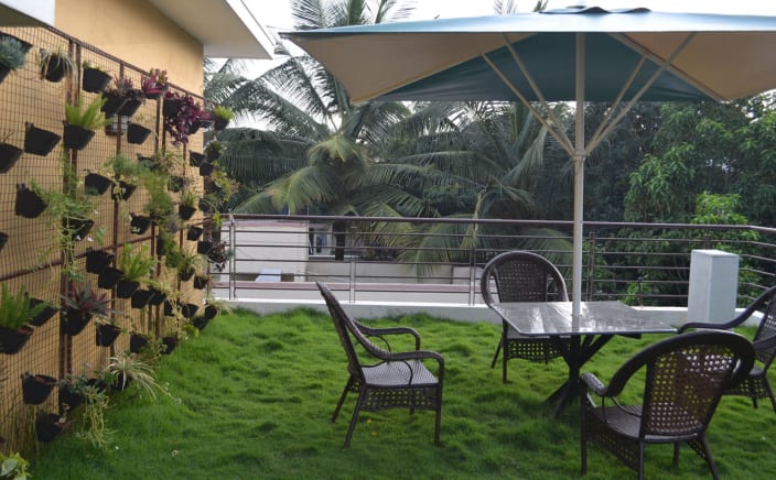 Black Patio Furniture In A Balcony With Fake Grass Carpet By Kiran Hanumaiah