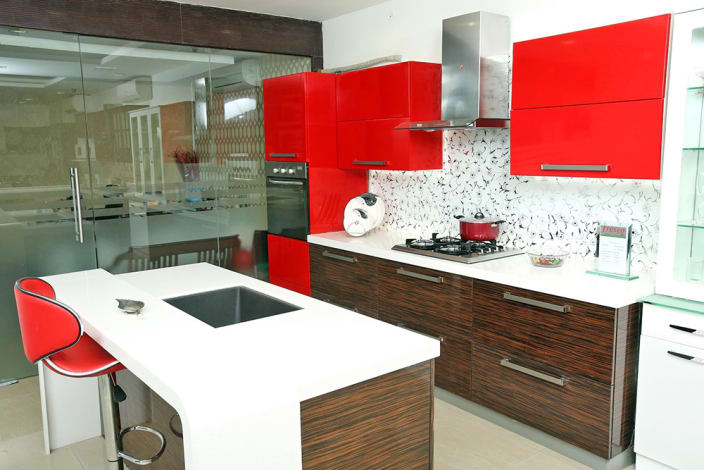 Open island kitchen with red cabinets by Reshma Rasheed 