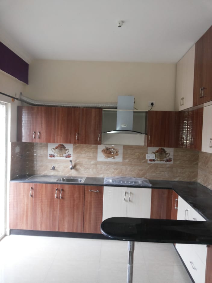 G Shaped Kitchen With Brown And White Cabinets by Dhanu 