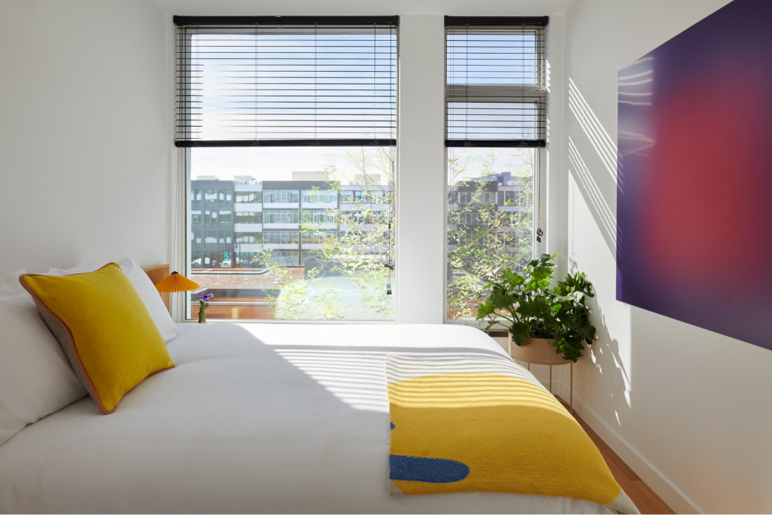 View of the designer bedroom details including Venetian blinds at Harrison Urby - luxury Harrison NJ apartments for rent