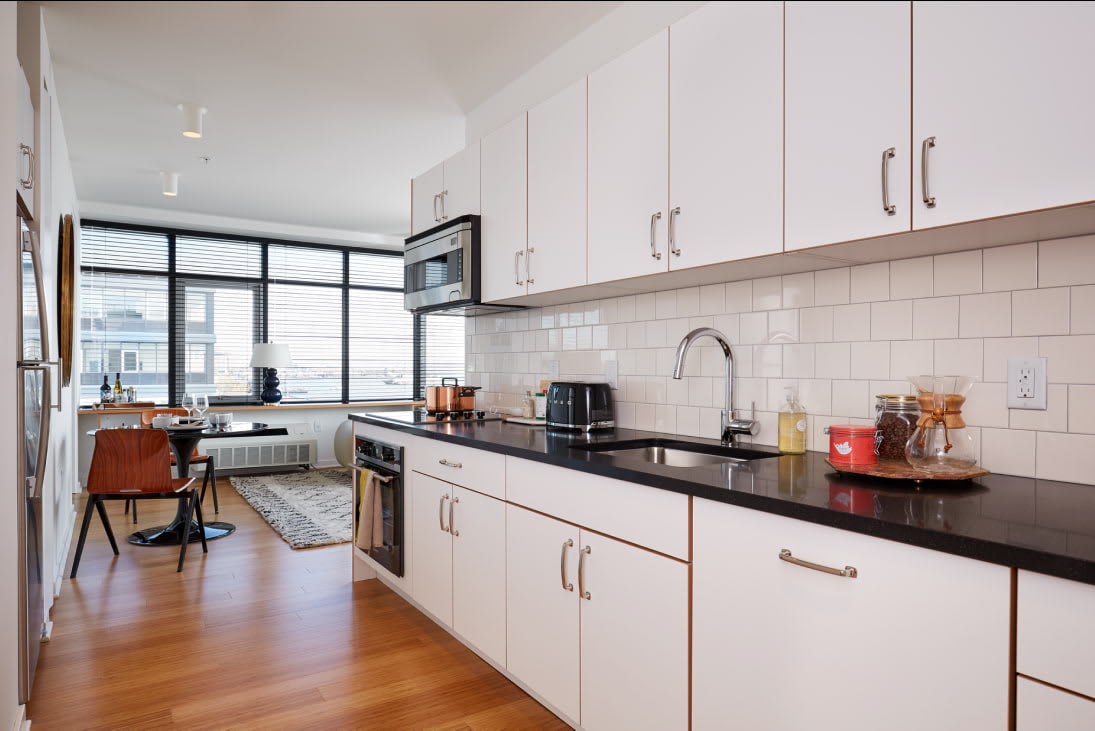 View of the designer kitchen with stainless steel appliances at Staten Island Urby - luxury Staten Island apartments for rent