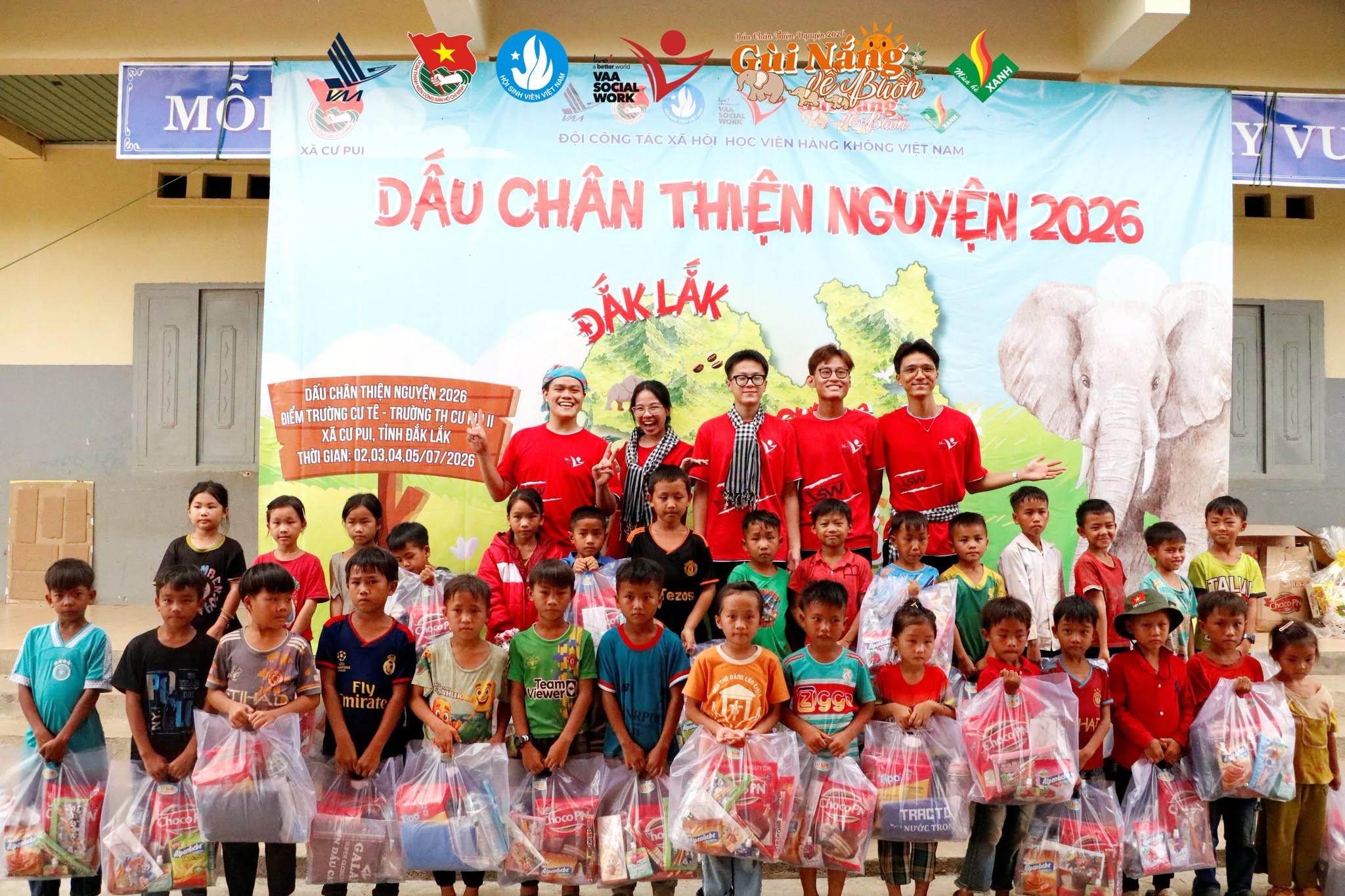 Các em học sinh xếp hàng nhận quà, ảnh trao quà trực tiếp thể hiện rõ niềm vui của các em.