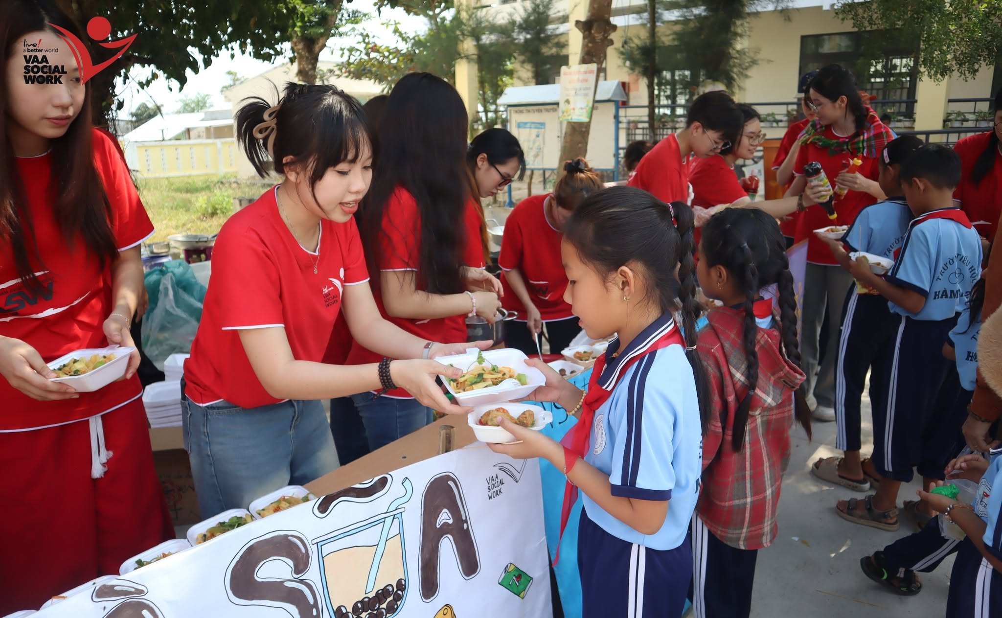 Các bạn thành viên đang phát các suất ăn cho các em học sinh.