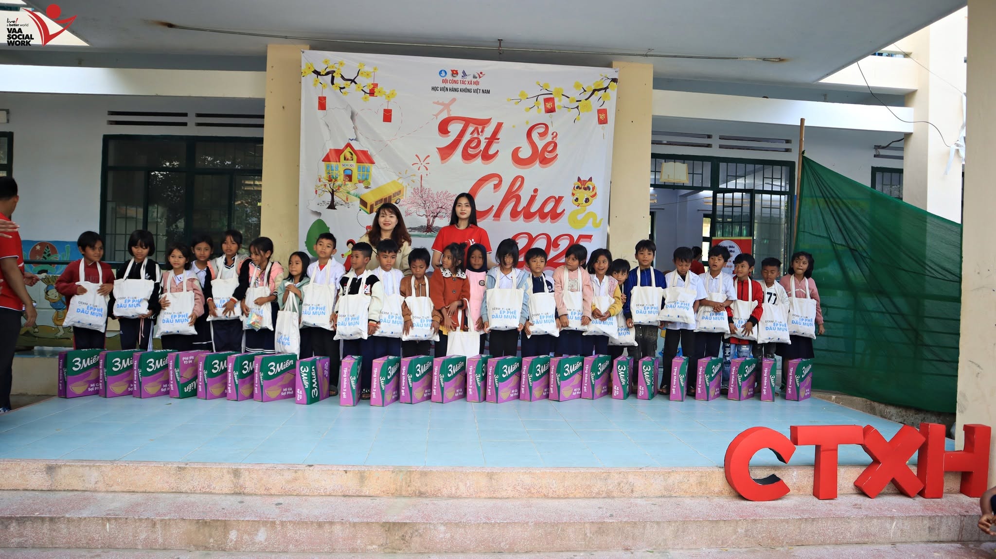 Các em học sinh xếp hàng nhận những phần quà.