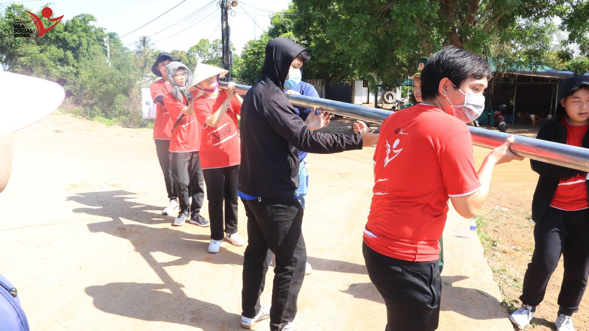 Thành viên đang thi công, hỗ trợ nhau lắp đặt trụ đèn.