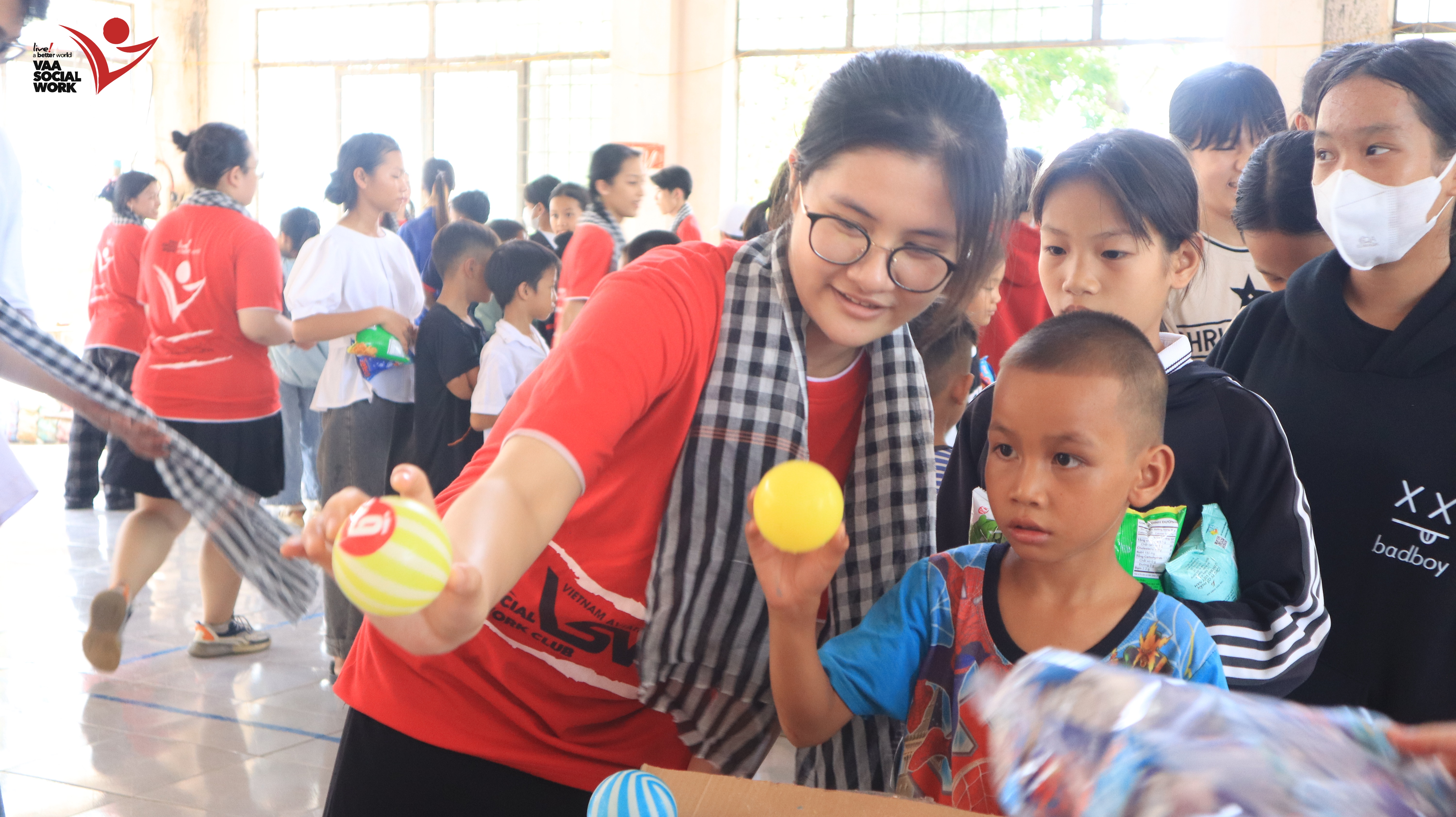 Các bạn thành viên đang hỗ trợ các em nhỏ chơi trò chơi.