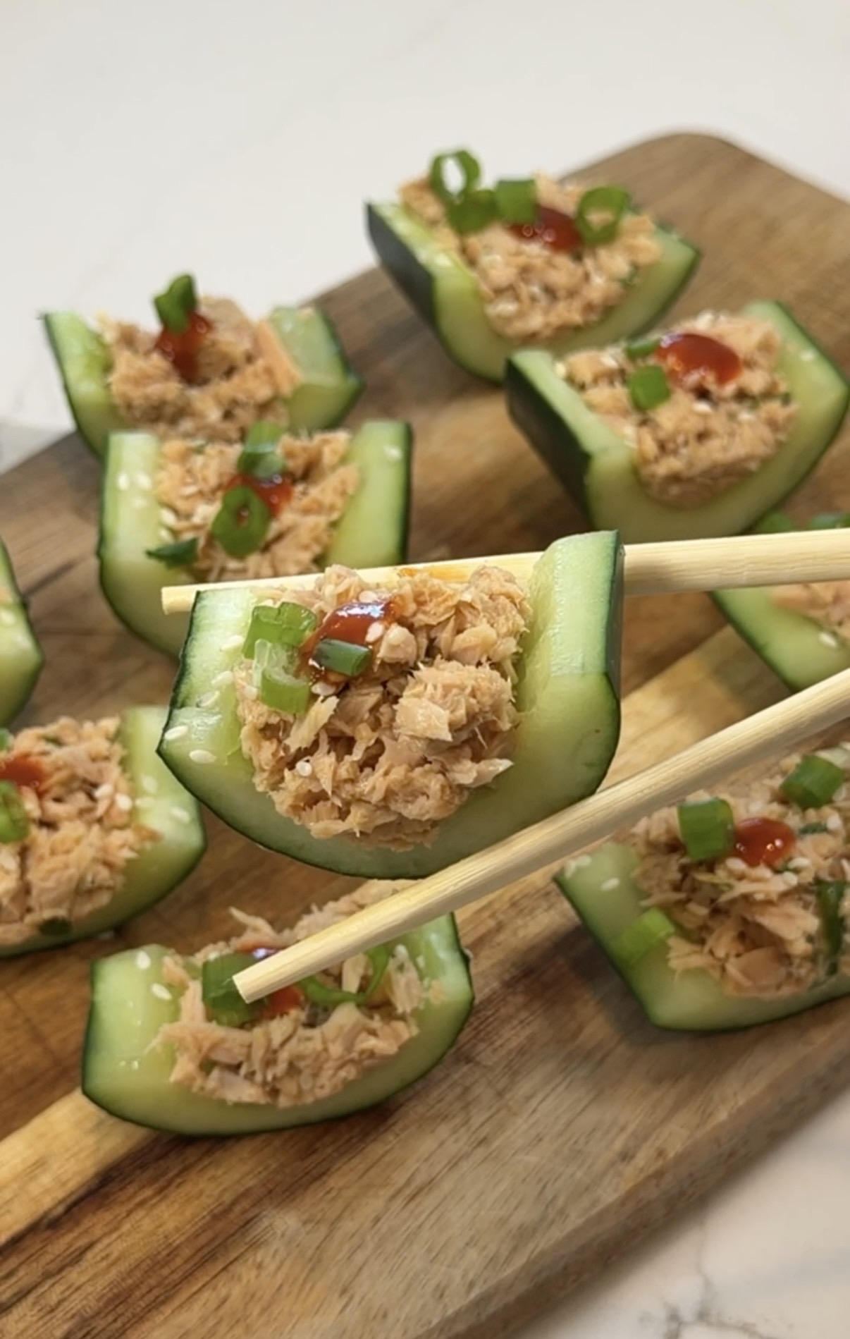 cucumber boats filled with spicy sriracha tuna and topped with sesame seeds and green onions