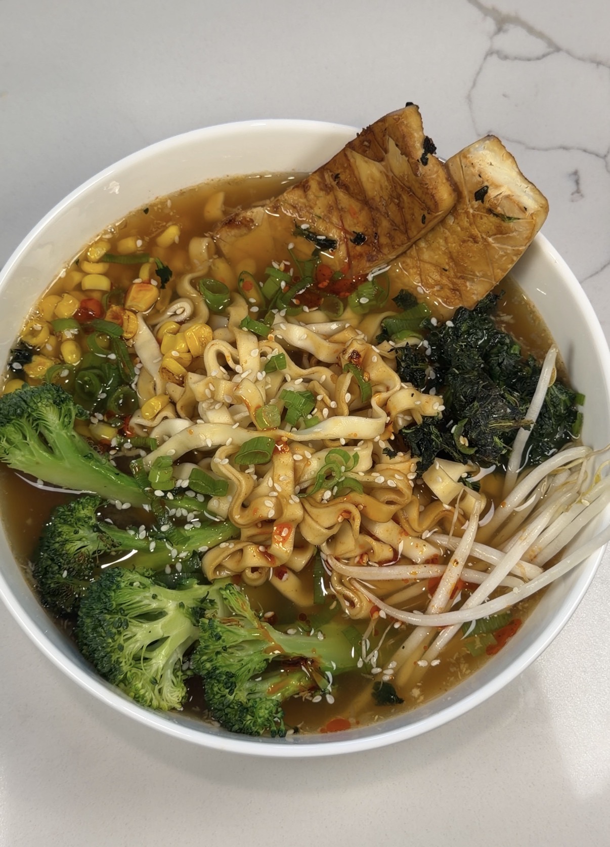 chili ramen with crispy tofu, bok choy, carrots, corn, miso broth, and a soft-boiled egg