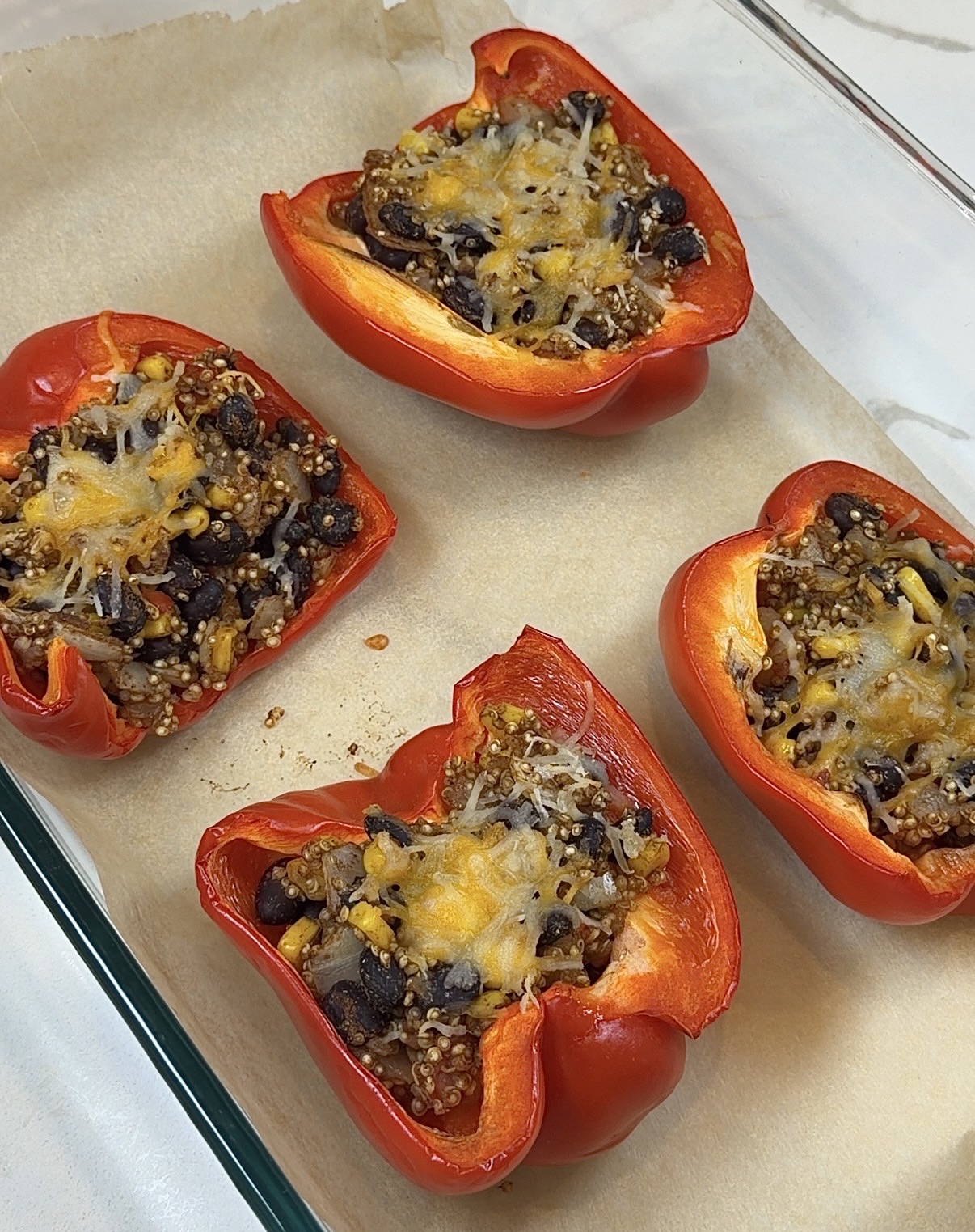 vegetarian stuffed bell peppers with quinoa, black beans, corn, tomatoes, and melted cheese