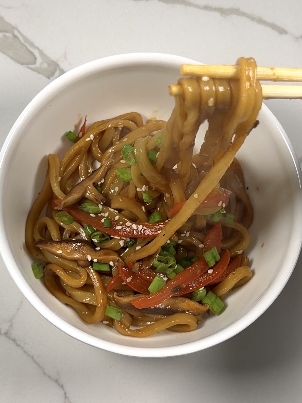 mushroom udon noodles with shiitake mushrooms, red bell pepper, green onions, and sesame seeds