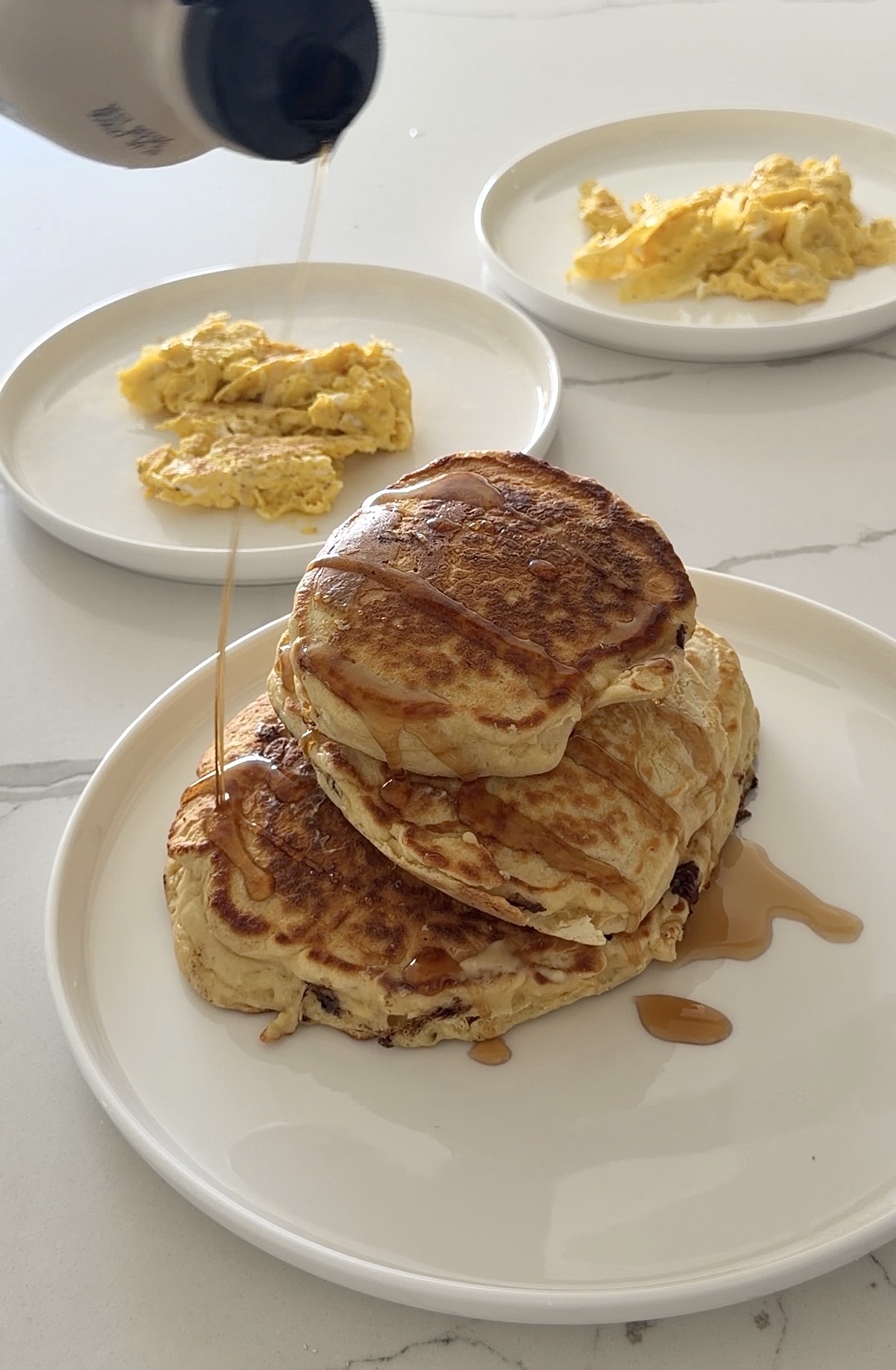 stack of fluffy homemade pancakes topped with maple syrup