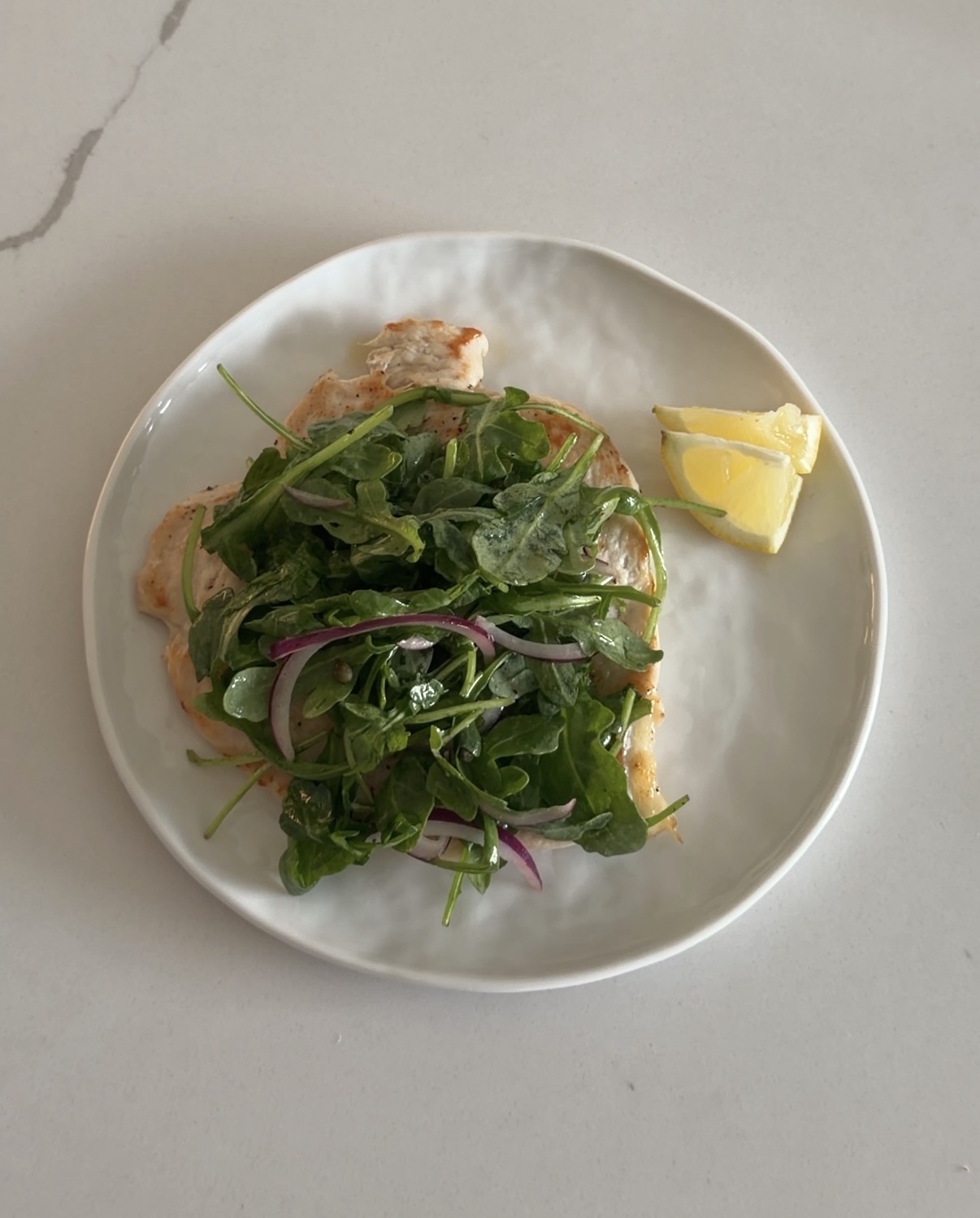 pan-seared chicken milanese topped with arugula, red onion, capers, and lemon dijon vinaigrette