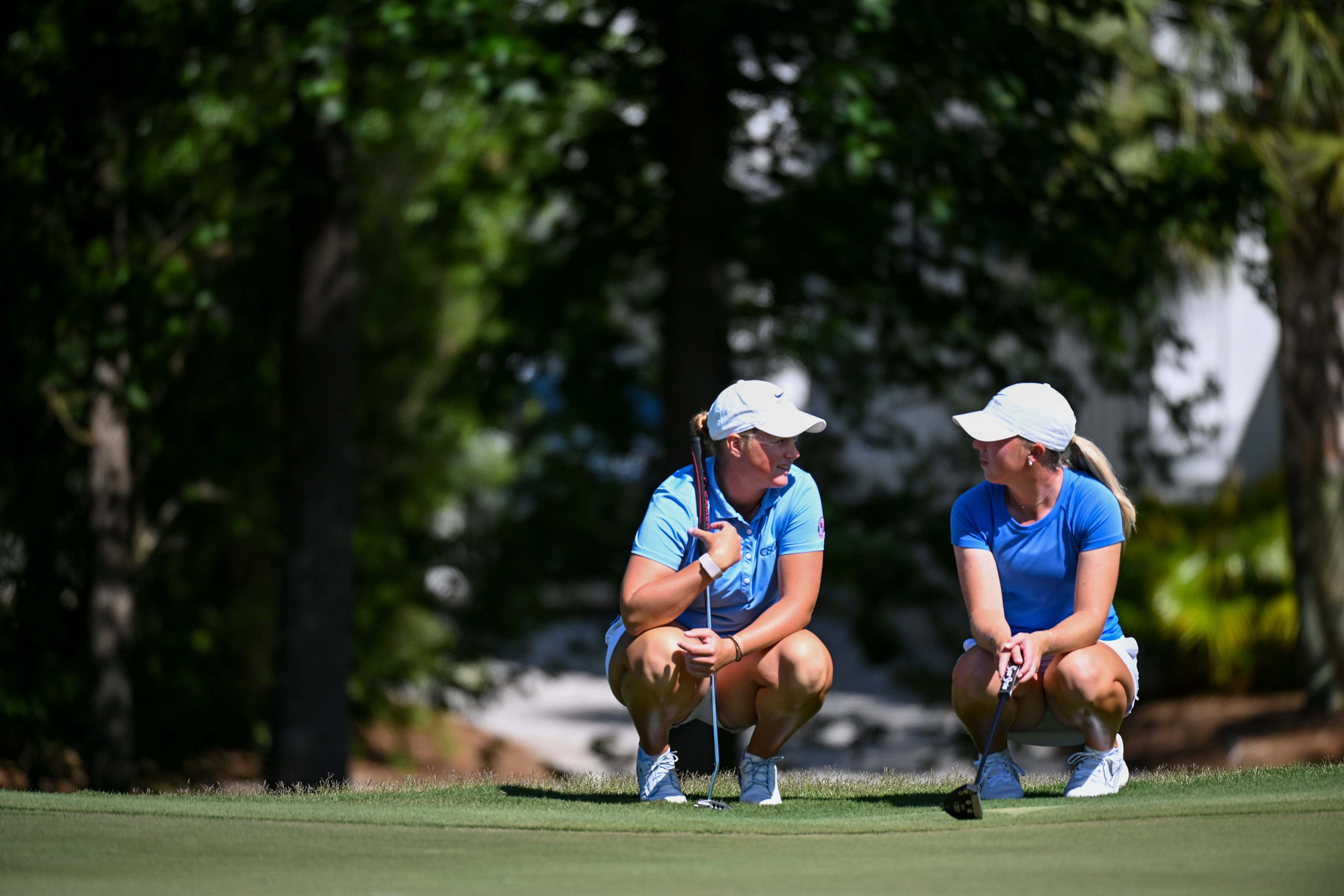 Mary Miller (left) and Sophie Linder keep things light as they discuss their putts on the fifth hole.  (USGA/Edward M. Pio Roda) 