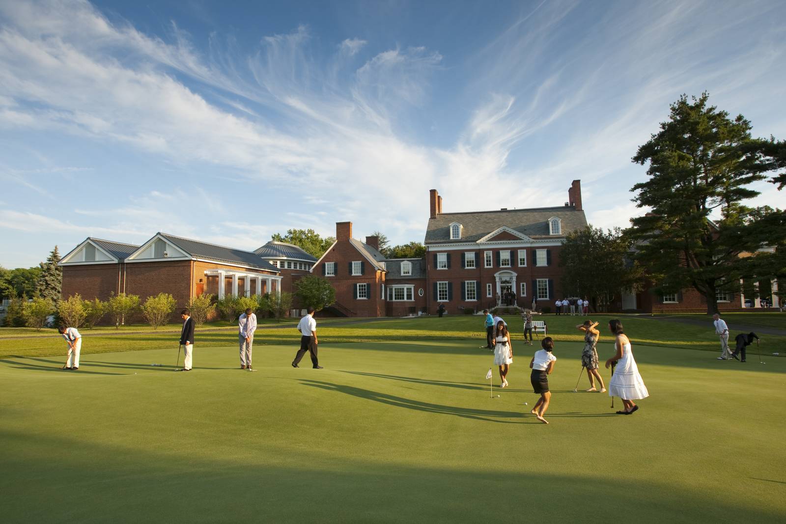 USGA Golf Museum front green where golfers in festive outfits are putting.