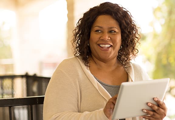 What-Body-Shape-Says-About-Health woman-smiling-holding-tablet
