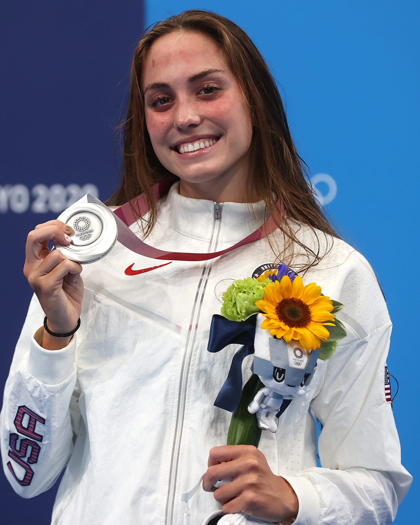 Emma Weyant smiles and proudly holds her silver medal