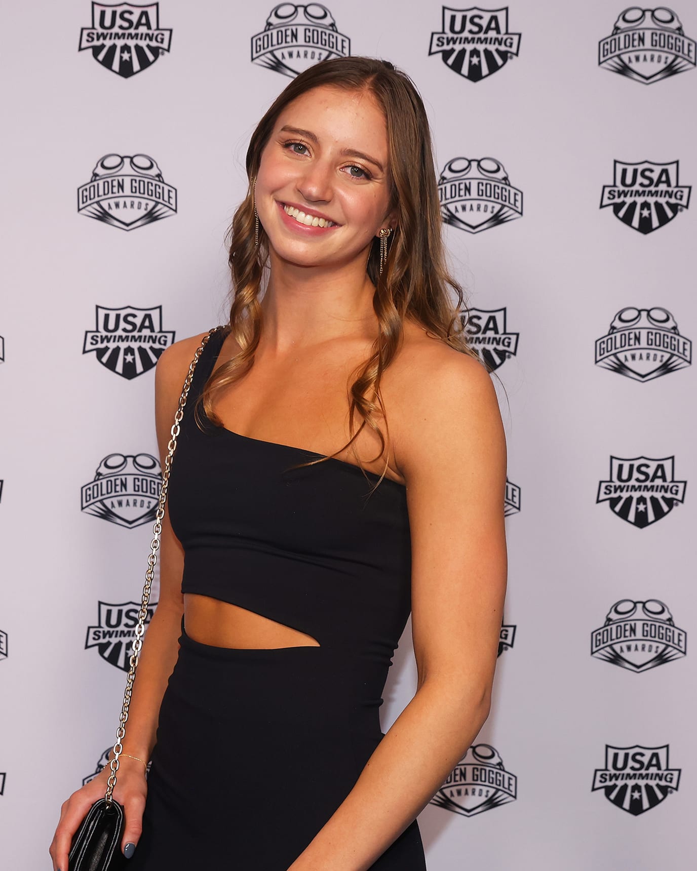 Kate Douglass smiles at the camera from the red carpet