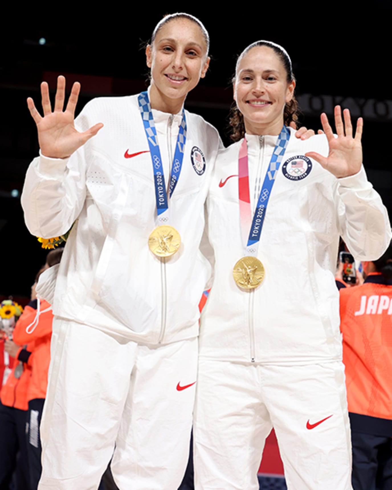 Diana Taurasi holds up five fingers while wearing a gold medal