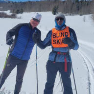 Mark Birdseye (left) poses with a visually impaired skier.