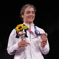 Helen Maroulis smiling and holding up her bronze medal