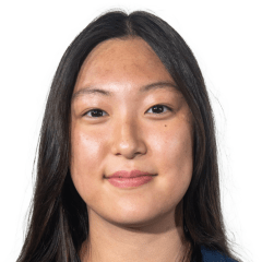 Audrey Kim stands in a US Paralympic shirt and looks at the camera on a white backdrop