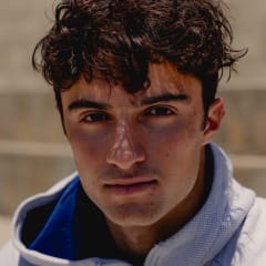 Ezra Frech sits by the track in Los Angeles, California