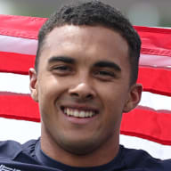 Kamren Larsen poses for a photo with the U.S. flag.